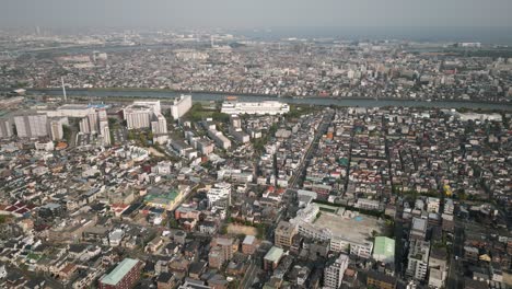 aerial scenic urban drone footage of a neighborhood, streets and buildings in the capital city of tokyo, japan during sunset