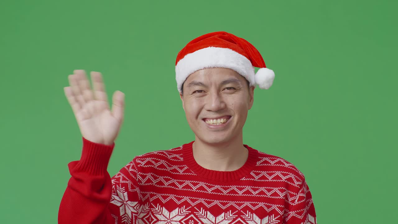 산타 모자를 입고 빨간 스웨터를 흔들고 있는 남자