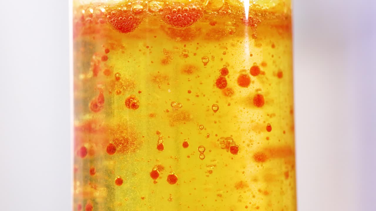 다채로운 액체 거품이 램프에 올라와 떨어집니다.