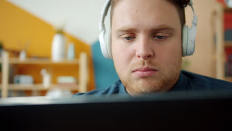 hombre trabajando en una computadora portátil con auriculares