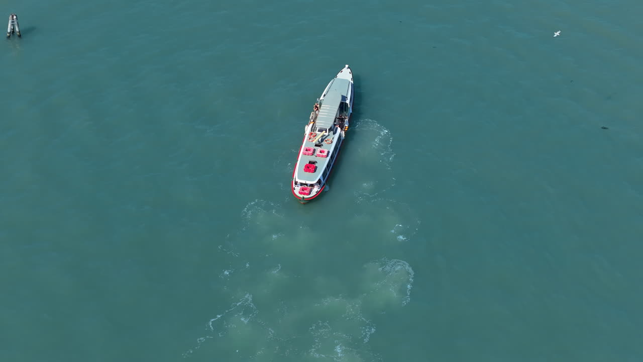 Aerial drone shot of a boat sailing on the canal at daytime in Venice, Italy