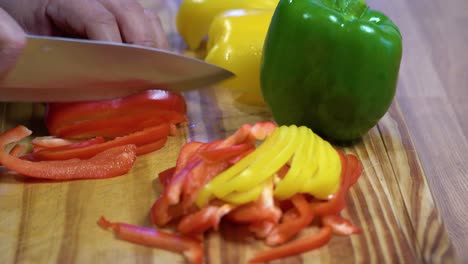rebanar pimientos en juliana sobre tablero de madera cocina dieta sana y saludable