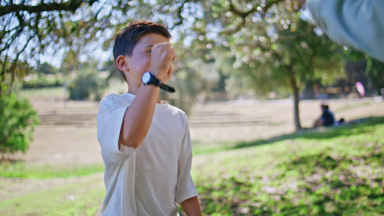 Boy playing rock-paper-scissors with dad at garden closeup. Child enjoying game