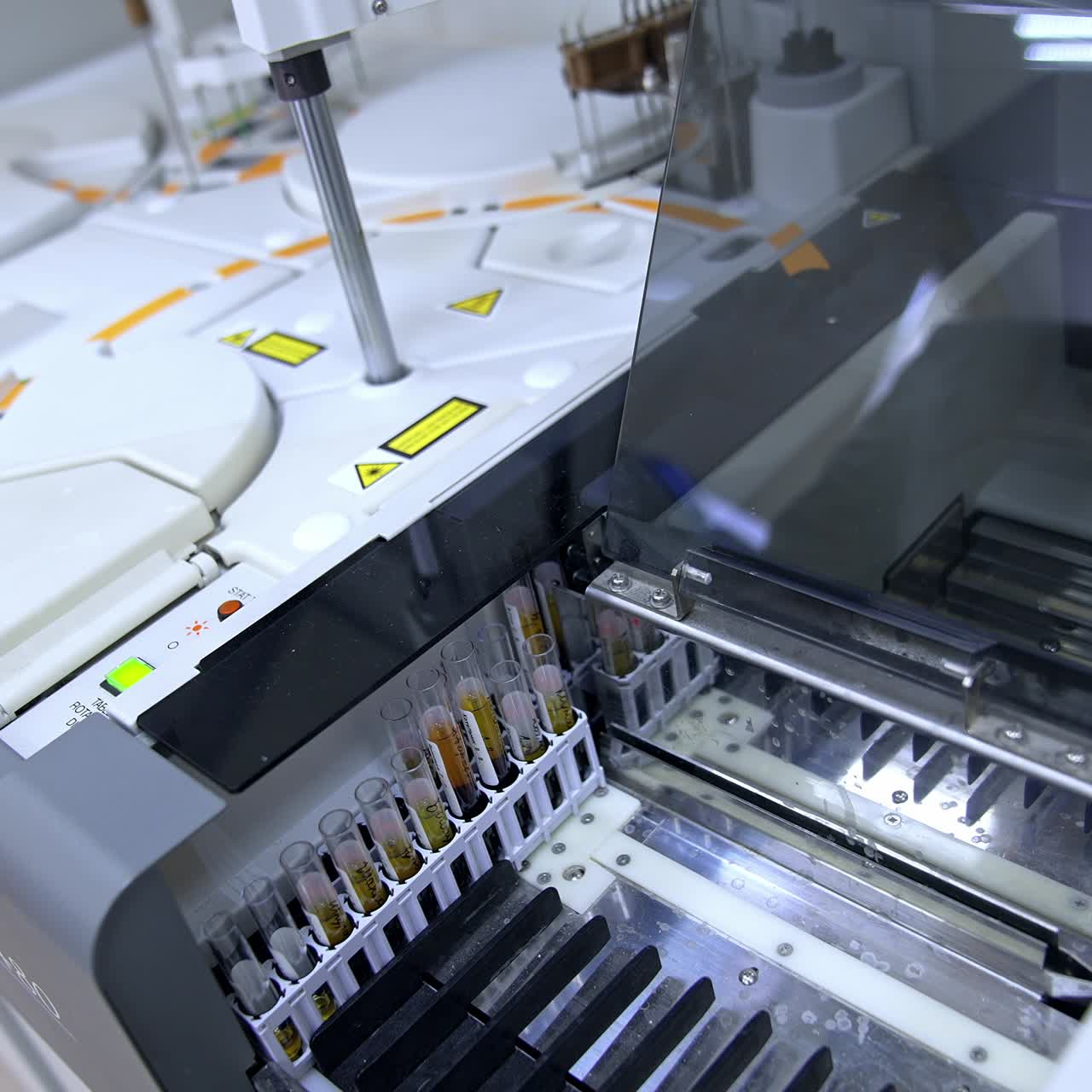 Modern advanced equipment performing science testing of blood in the hospital laboratory. Test glasses are moving inside the machine