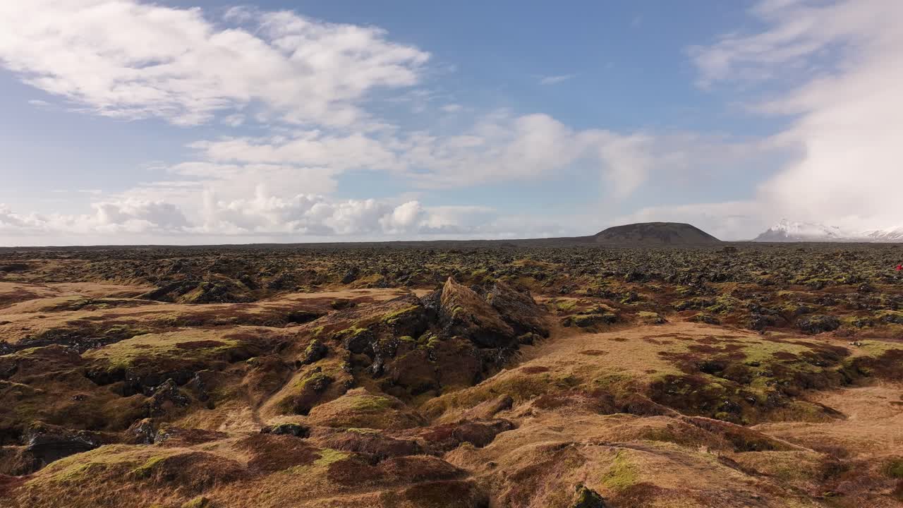 Wide aerial view over mossy lava fields near Búðir, Snæfellsnes Peninsula, Iceland. Volcanic textures and open skies define this dramatic, untouched Icelandic terrain.