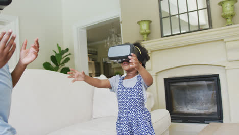 happy african american girls using vr headsets in living room