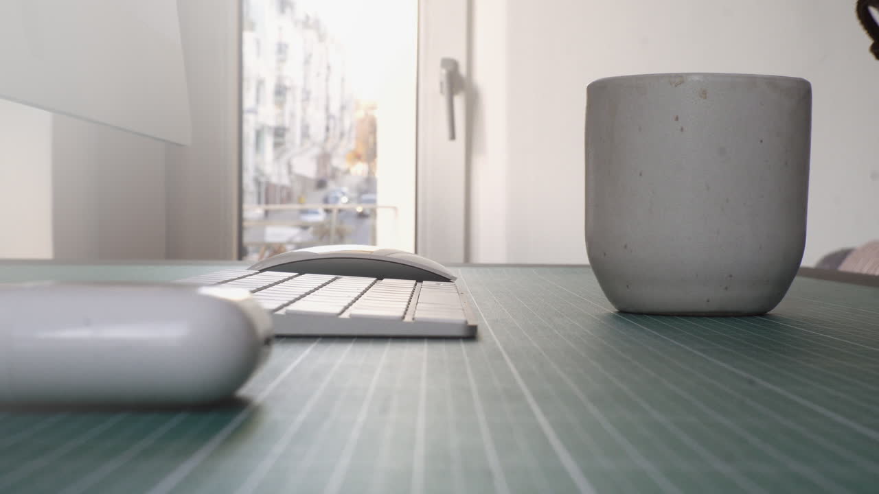 4k 작업을 하는 홈 오피스 스튜디오에 있는 그의 책상에서 전문적인 창조적인 밀레니엄 세대가 커피를 따르고 있습니다.