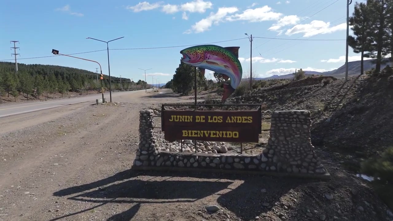 Welcome sign greeting visitors to junin de los andes, a popular fishing destination in neuquen, patagonia, argentina, featuring a large trout statue
