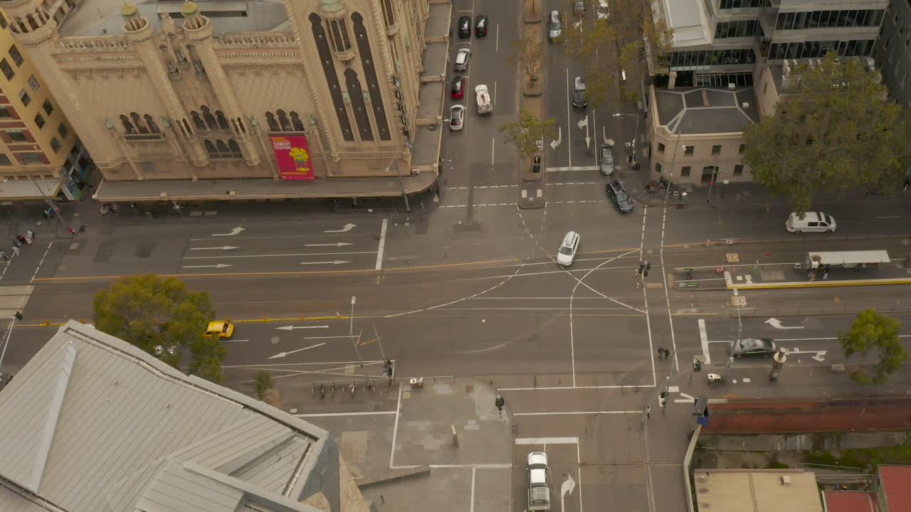 Static perspective of Melbourne intersection as vehicles make a hand turn through the intersection toward camera perspective