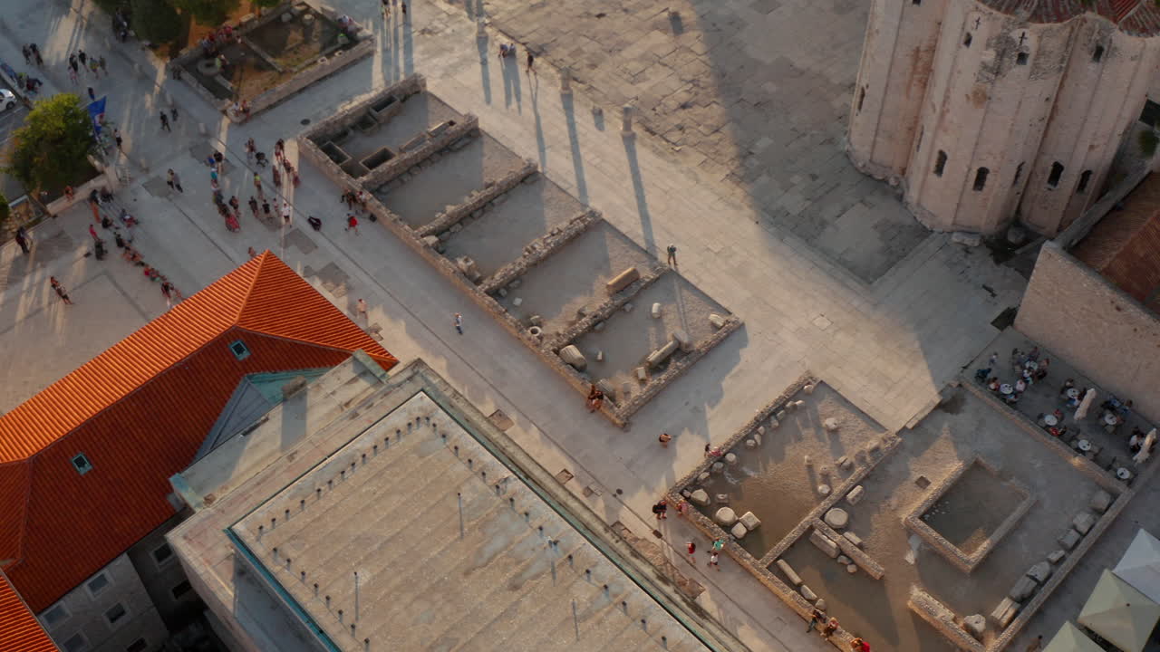 gente caminando por las ruinas del foro romano frente al museo arqueológico de zadar en croacia