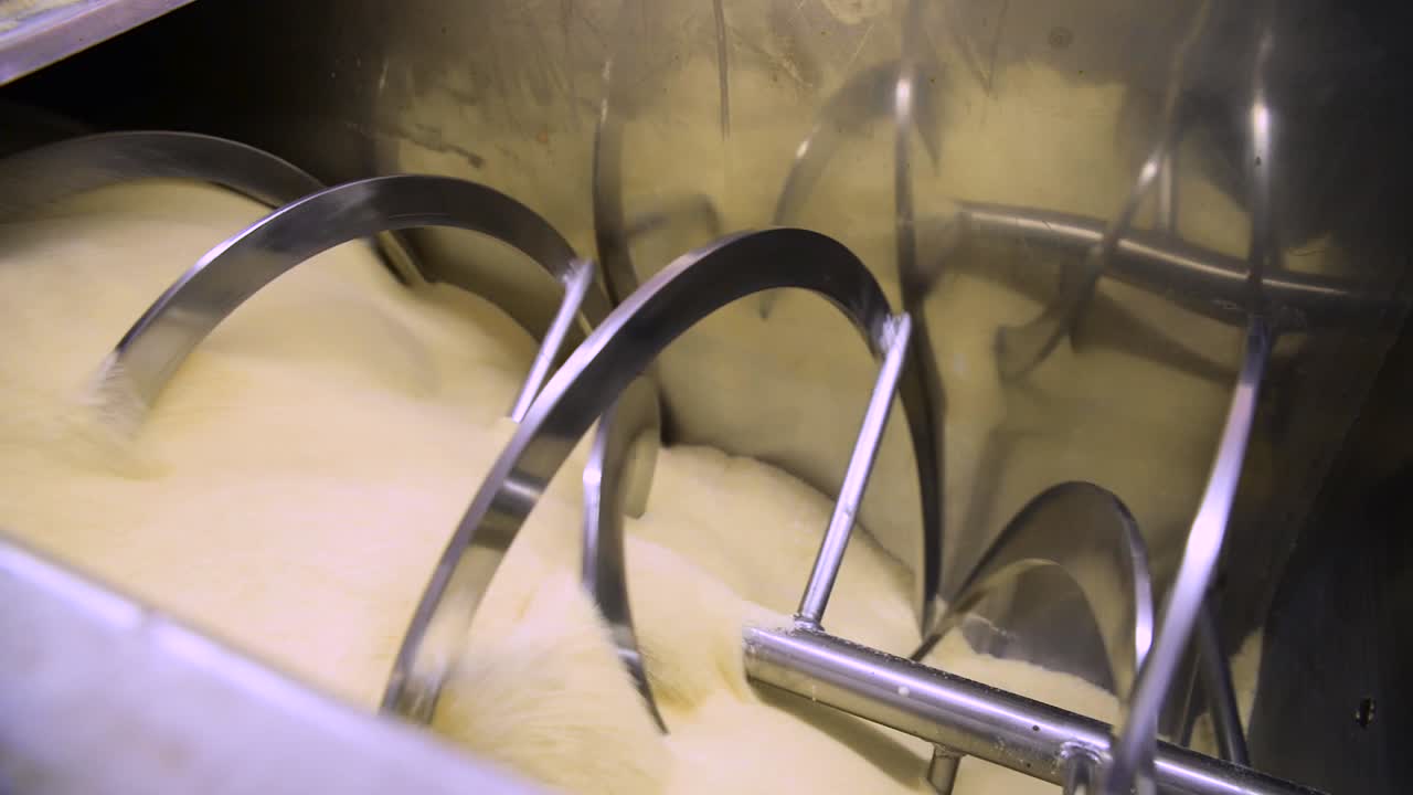 enorme máquina mezcladora de polvo de harina rodando ingredientes en una fábrica de pan