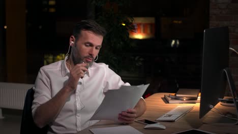 mature man talking by mobile phone in office at night