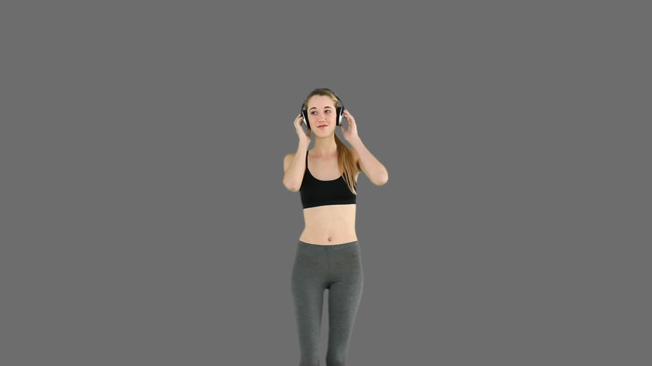 Modelo fitness ouvindo música e dançando