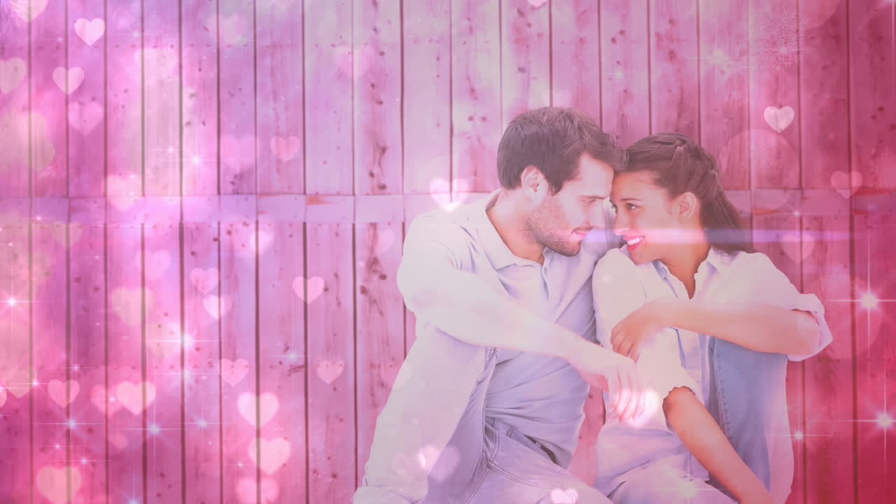 울타리에 맞서 앉아 있는 행복한 커플