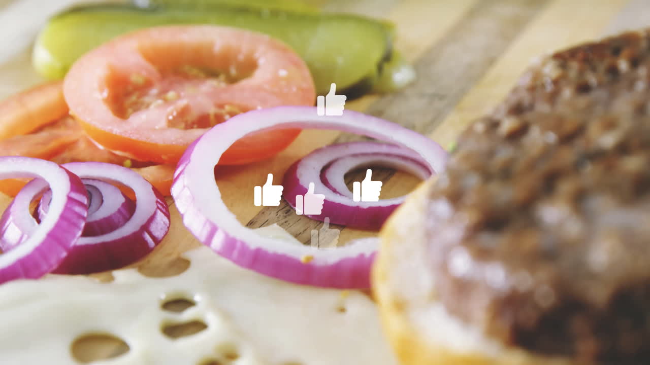 Animation of burger ingredients with thumbs-up icons over sliced onions and tomatoes