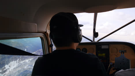 piloto volando un avión sobre una montaña cubierta de nieve 4k