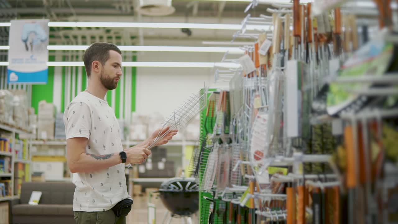 hombre comprando accesorios para parrillas de barbacoa en una tienda