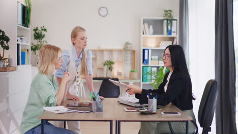 Three-Female-Employees-Discuss-Project-During-Meeting