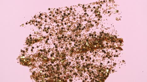 brushstrokes of gold paint brush applied isolated on a pink background. gold paint smear texture. shine, stars, sparkles. golden sparkling textured artistic illustration. smears of cosmetics.