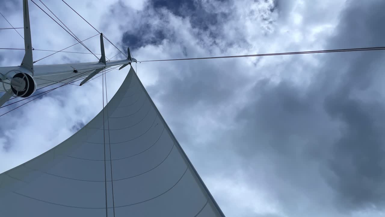 A Sail moving in the wind with clouds over head. 4K UHD