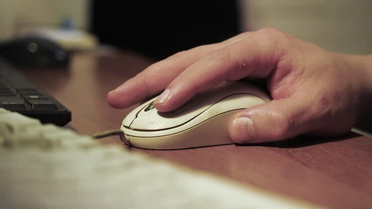 Hand using a computer mouse on a desk