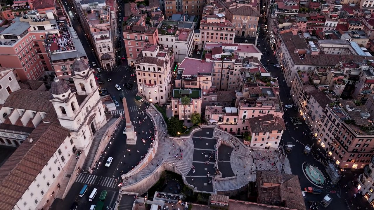 La folla si muove attraverso Piazza di Spagna e la Scalinata di Trinità dei Monti mentre il traffico circola nelle strade circostanti all'ora blu.