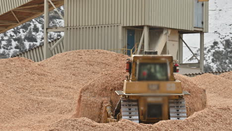 bulldozer clears sawdust in bustling industrial zone