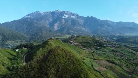 Hermosa-Toma-De-Drones-De-Los-Campos-De-Kundasnag-Que-Muestra-El-Monte-Kinabalu-Al-Fondo,-Sabah-Malasia,-A-La-Luz-Del-Día