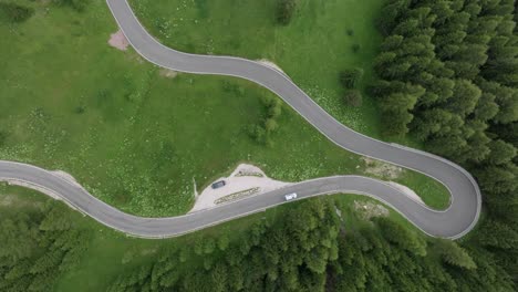 An-aerial-perspective-reveals-multiple-cars-navigating-the-winding-roads-near-Selva-Pass-in-the-Dolomite-Mountains,-Trentino,-South-Tyrol,-Italy