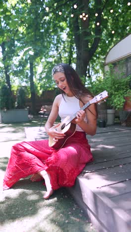 woman playing ukulele in a garden