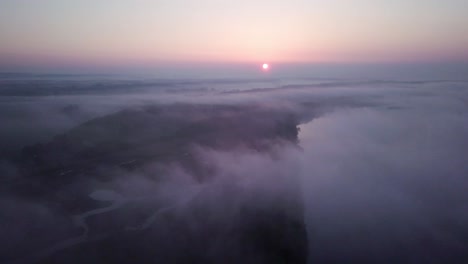 4k aerial view of sunrise above clouds at the landscape park in poland