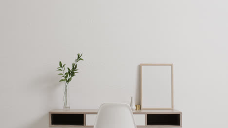 wooden frame with copy space on white background with plant on desk against white wall