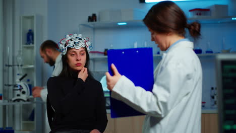 Ill-woman-listening-neurological-doctor-looking-at-clipboard