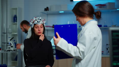 mujer enferma escuchando médico neurológico mirando el portapapeles