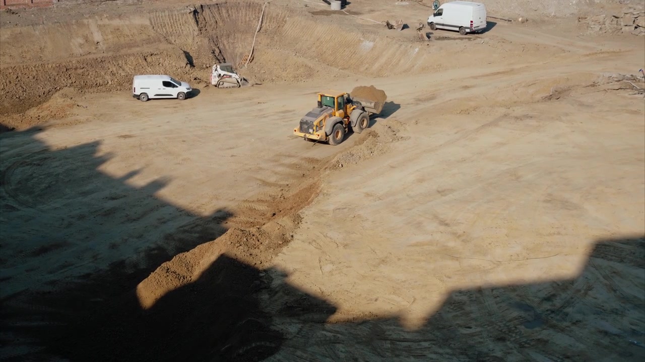 Heavy-Duty Scooptram Loader Excavating and Transporting Dirt at a Construction Site. Scooptram transporting materials from the excavation site to a dumping location. Scooptram clearing obstacles.
