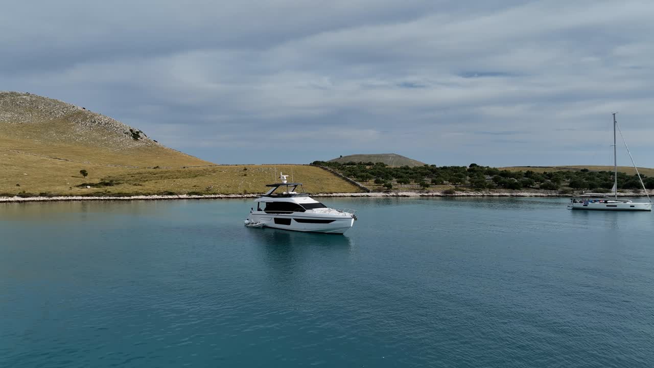 A boat sailing in a serene bay near Kornati, surrounded by calm waters and hills