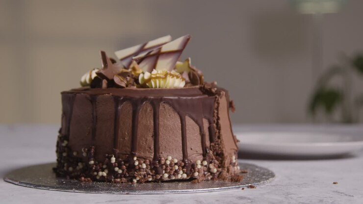 Close Up Shot Of Person At Home Cutting Slice From Chocolate Celebration Cake On Table 1