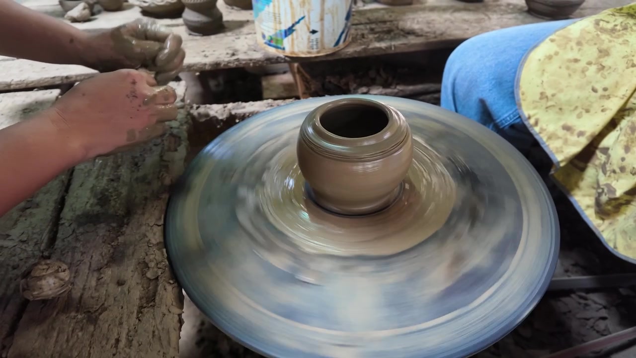 Primo piano di mani che modellano un vaso di ceramica su un tornio a Nonthaburi, Thailandia.