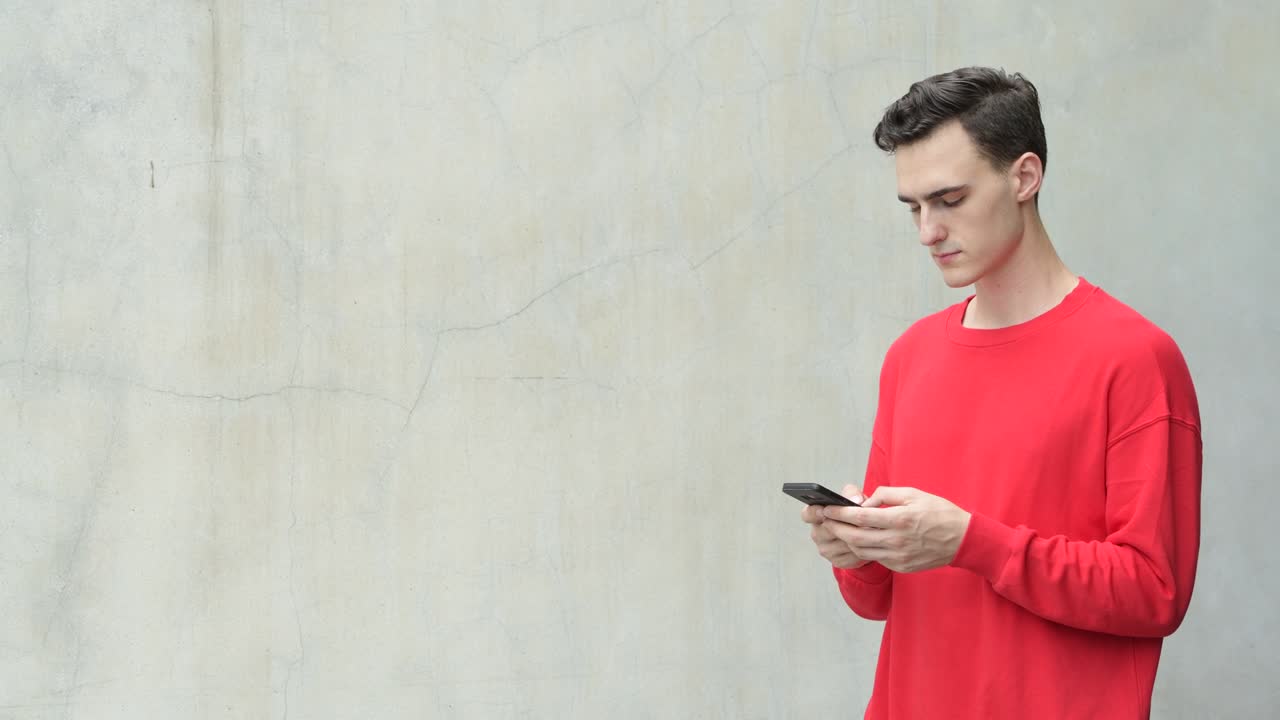 전화를 사용하는 행복한 젊은 잘생긴 남자