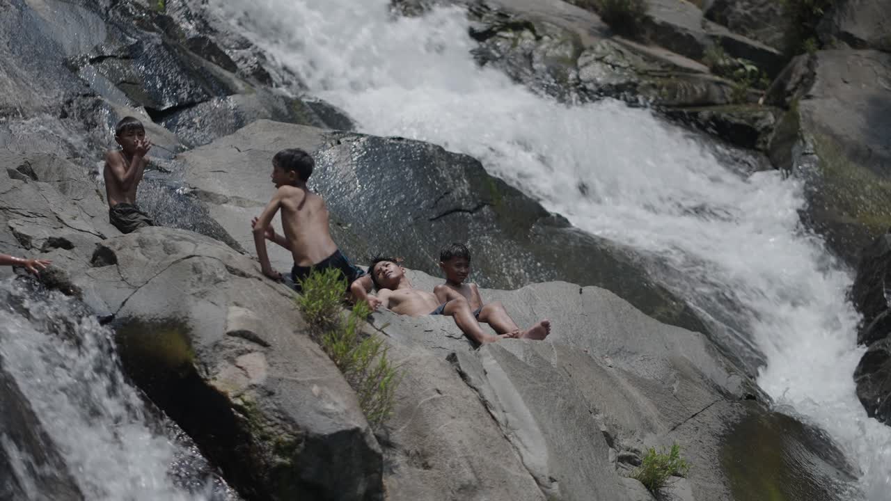 Children Playing at a Waterfall