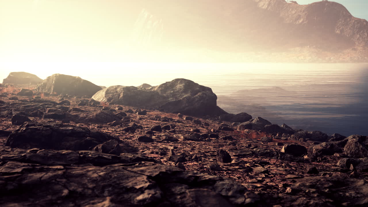 바위가 있는  ⁇ 은 강은 해가 지면에 빛나는 산으로 이어집니다.