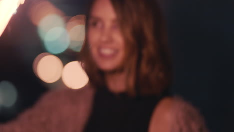 portrait-beautiful-young-woman-holding-sparkler-celebrating-new-years-eve-dancing-on--rooftop-at-night-enjoying-holiday-celebration