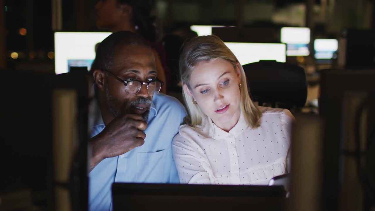Professional businessman and businesswoman discussiong over digital tablet while sitting in modern o