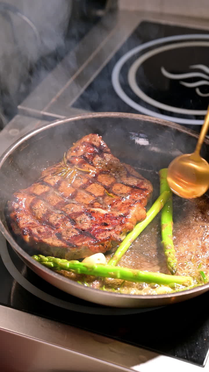 Steak with asparagus in frying pan. Grilled steak with asparagus and garlic cooking in a frying pan
