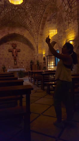 tourist taking pictures inside knights halls church in acre old city, israel.
