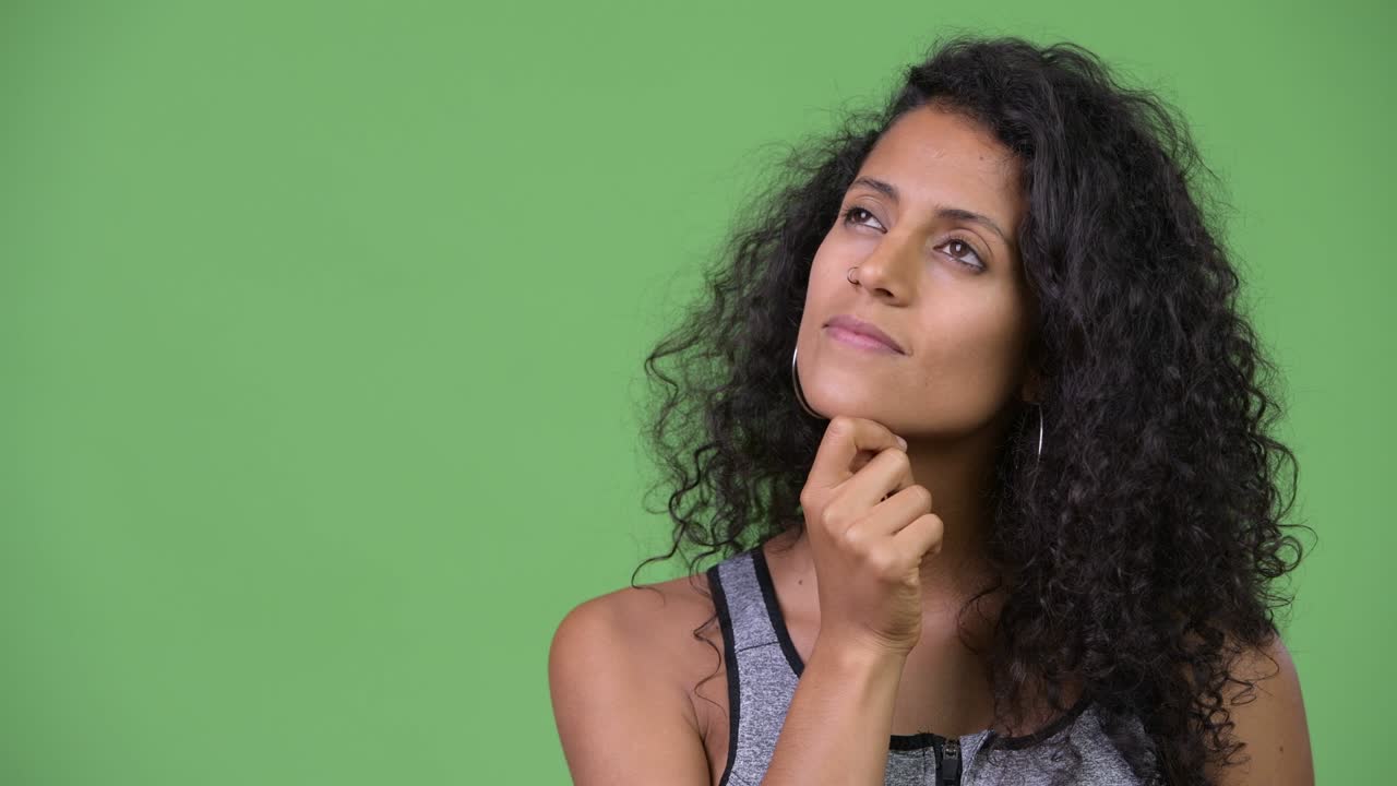 Young beautiful Hispanic woman with gym clothes thinking