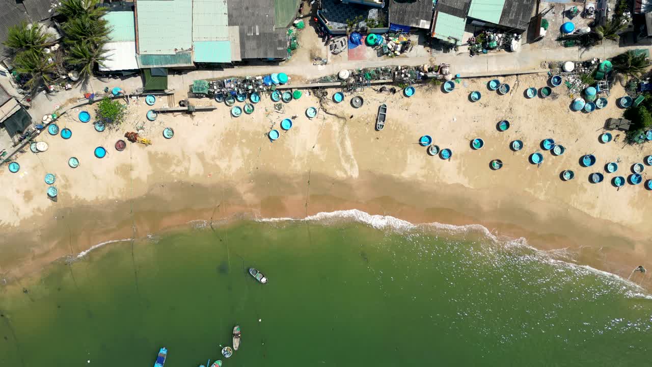 Stunning top down drone view over beautiful sandy beach at Vietnamese fishing village