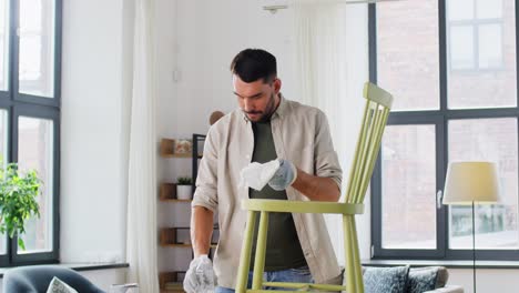 Man-Applying-Solvent-to-Rag-and-Cleaning-Old-Chair