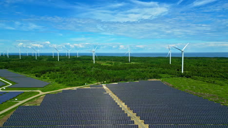 Wind-turbines-and-solar-panels-in-Paldiski-Wind-Park,-Estonia-on-a-sunny-day,-aerial-view