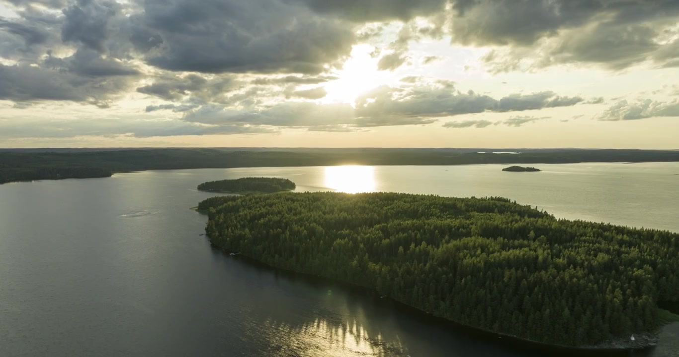 Aerial hyperlapse of clouds moving over islands on a lake, golden hour in Finland